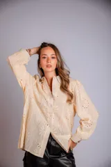 Camisa de broderie color beige, con hombros y mangas globo, de corte suelto.