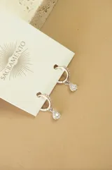 Aros tipo argolla plateados con circonitas y dije colgante en forma de gota con circonitas.