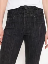 Pantalón de jean negro de tiro alto, corte acampanado y textura rayada vertical.