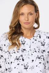 Blusa blanca estampada con hojas en color azul, de manga larga abullonada y cuello redondo.