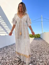 Vestido túnica largo de color celeste con bordados dorados y detalles de encaje en el escote y ruedo.