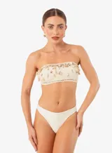 Conjunto de bikini color crema, con corpiño bandeau de crochet con apliques de caracoles y bombacha clásica lisa.