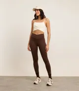 Top deportivo blanco de microfibra con escote recto, breteles finos ajustables y bajo torcido.