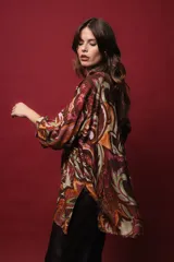 Camisa de seda de algodón estampada con arabescos en tonos marrones, verdes, naranjas y dorados. Tiene corte holgado, abertura frontal y lurex dorado.