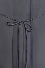 Camisa gris de satén con cuello solapa, escote en pico, mangas largas abullonadas y cierre frontal con botones metálicos.