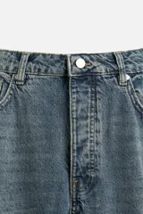 Pantalón cargo de denim color beige, corte relaxed fit, con bolsillos laterales tipo parche con solapa y cierre frontal con botones.