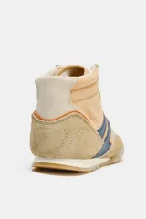 Zapato deportivo tipo botín color beige con detalles en azul y naranja.