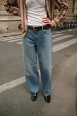 Pantalón de jean celeste de corte recto, tiro medio y cinco bolsillos. Incluye cinturón negro con hebilla plateada.