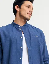 Camisa de lino color beige, de cuello mao y manga larga.