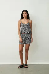 Short negro de tiro alto con cordón ajustable en la cintura y bolsillos laterales. Presenta un corte holgado y ruedos redondeados.