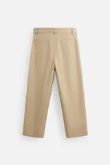 Pantalón negro de corte ancho con cinturón de tela con hebilla metálica y pliegues frontales.