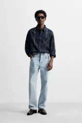 Pantalón de jean celeste de corte recto, con cinco bolsillos, efecto lavado y cierre frontal con botones.