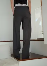 Pantalón de vestir gris marengo, de corte recto y tiro medio, con pinzas delanteras, bolsillos laterales y cierre frontal oculto con botón, gancho y cremallera.