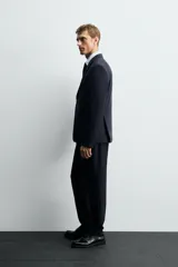 Blazer slim fit color verde oliva, confeccionada en tejido con viscosa. Tiene cuello con solapas de muesca, manga larga con puños abotonados, bolsillo de vivo en el pecho, bolsillos de solapa en la cadera, bolsillo interior, aberturas en la espalda y cierre frontal con botones.