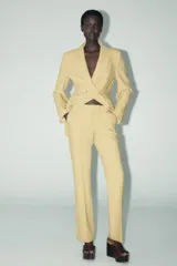 Blazer amarillo mostaza de cuello solapa y manga larga. Cierre frontal cruzado con botones forrados y bolsillos con solapa en delantero.