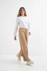 Pantalón jean color beige, de corte ancho y tiro alto.
