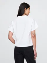 Remera rosa con estampado de la banda Nirvana y logo en verde y celeste.