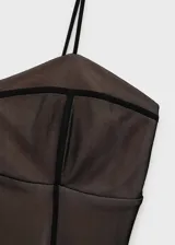 Vestido corto negro de malla transparente con forro interior, escote corazón, tirantes finos y cierre de cremallera invisible en la parte posterior.