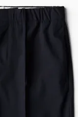 Pantalón de vestir negro de corte recto con cintura elástica y cordón ajustable. Tiene bolsillos laterales y traseros.