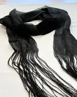 Bufanda de hilo color negro con flecos en los extremos.