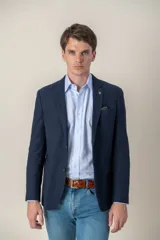 Saco sport color beige de jersey, corte slim fit, con cierre de dos botones, solapa de muesca, bolsillo de parche en el pecho y bolsillos delanteros con solapa.