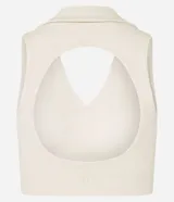 Top deportivo blanco hueso de microfibra, sin estampa, con cuello polo, escote V y recorte abierto en la espalda.