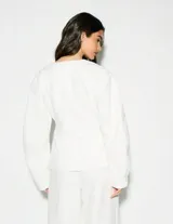 Blazer estructurado color blanco con escote en V, cierre frontal con botones y mangas largas.