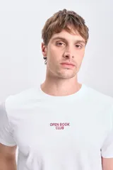 Remera blanca de manga corta con estampa en la espalda de un libro abierto y la frase "Open Book Club Since 1969 Brooklyn, NY".