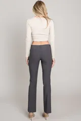 Pantalón negro de corte recto, tiro bajo y pierna angosta.