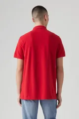Chomba manga corta color rojo, con cuello clásico y tapeta de dos botones. Logo de la marca bordado en el pecho.