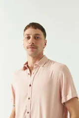 Camisa color rosa claro, de manga corta con dobladillo y cuello clásico. Corte slim fit.