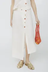 Falda midi color fucsia con botones dorados al frente y abertura lateral.