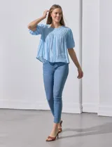 Blusa celeste de gasa marca Zac & Rachel, con cuello redondo, frunces en el frente, mangas 3/4 con puño, abertura central en la espalda y botón.