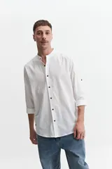 Camisa azul de manga larga con cuello mao y cartera abotonada.