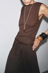 Top marrón de tejido de punto, sin mangas, con cuello fluido y detalle drapeado.