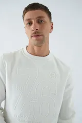 Buzo de algodón blanco con cuello redondo, manga larga y logo en relieve.