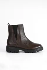 Bota Chelsea de cuero color marrón con elástico negro en los laterales y suela track negra.
