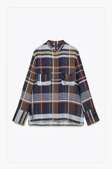 Camisa de mujer confeccionada en viscosa con estampado a cuadros en tonos azul, naranja, blanco y amarillo. Tiene cuello mao, manga larga con puños plisados, dos bolsillos de parche con solapa en el pecho, bajo recto y cierre frontal con botones ocultos.