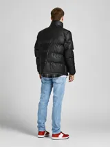Campera puffer negra de cuero sintético con cuello alto, cierre frontal con cremallera, bolsillos delanteros con solapa y puños elásticos.