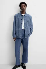 Pantalón azul de corte recto, con cintura ajustable, bolsillos laterales y traseros, y bolsillo tipo plastrón en la pierna. Tiene un lavado vintage con efecto de manchas.