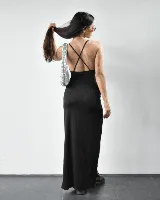 Vestido largo negro de satén con breteles finos, escote drapeado y abertura lateral en la pierna.