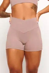 Short deportivo color nude, de tiro alto y corte ajustado. Presenta cintura cruzada en forma de V.