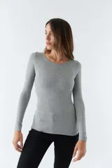 Remera gris de punto canalé, con escote redondo y mangas largas.