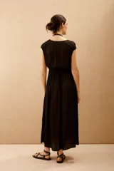 Vestido largo negro con escote en V y mangas cortas caídas.
