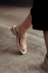 Sandalias bajas doradas de cuero, con punta cuadrada, tiras anchas y cierre con hebilla ajustable.
