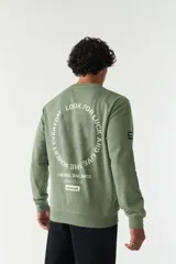 Buzo verde oliva de felpa con cuello redondo, puños y cintura acanalados. Estampado frontal con la frase "The Real Balance" en letras blancas y logo de la marca Mistral.