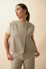 Chaleco marrón con solapas amplias y terminaciones envivadas. Diseño reversible y sin mangas.