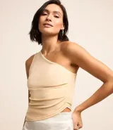 Blusa color beige claro, de poliéster y elastano, con escote asimétrico de un solo hombro, sin mangas, con fruncidos laterales y bajo asimétrico.
