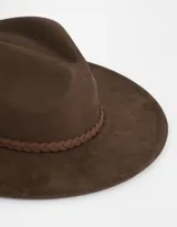 Sombrero marrón de gamuza con cinta trenzada alrededor de la base de la copa.