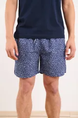 Short de baño azul con estampado de hojas blancas y cordón ajustable en la cintura.